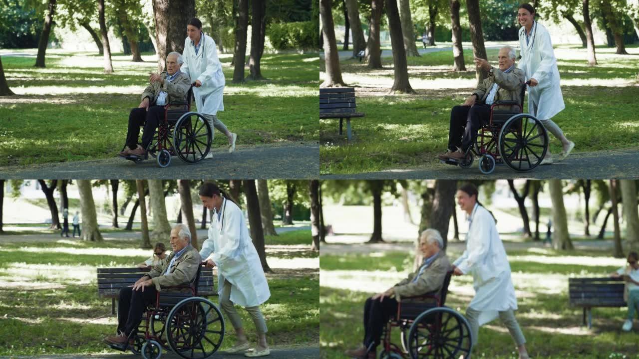 快乐的年轻女社会工作者或坐在轮椅上的护士和老人在绿色公园一起散步的电影。医疗保健、寄宿房、援助、残疾