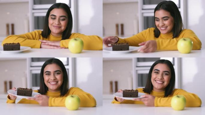 4k视频片段，一名年轻女子决定在家中吃苹果还是巧克力蛋糕