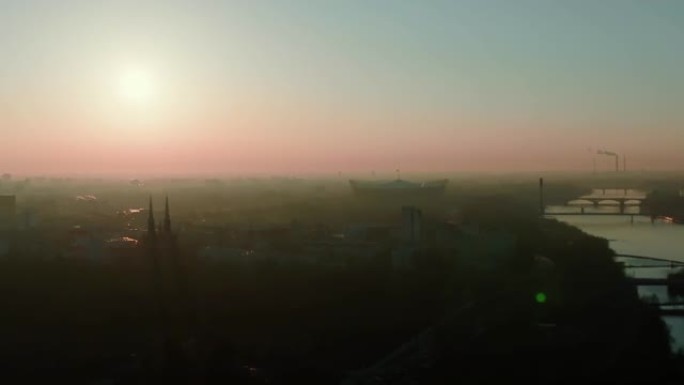 雄伟的空中全景，太阳升起在史诗般的大气雾蒙蒙的华沙城市景观，维斯拉河上的体育场和桥梁。