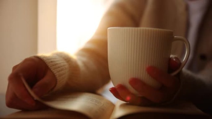 女人手握咖啡杯看书
