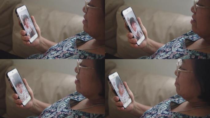 祖母与家人一起使用智能手机视频会议。