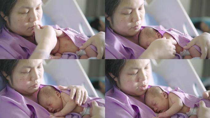 在医院的母亲温暖的胸前睡觉的新生婴儿