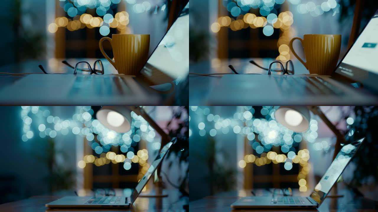 DS笔记本电脑，眼镜和桌子上的杯子，背景为bokeh