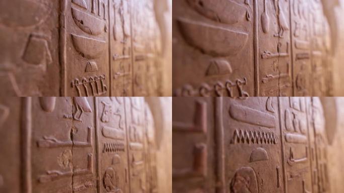 哈特谢普苏特神庙墙上的埃及象形文字的近景。古埃及象形文字雕刻的仿古石墙。浅景深