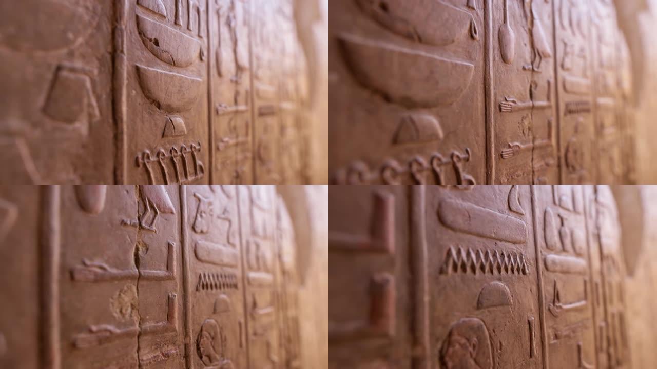 哈特谢普苏特神庙墙上的埃及象形文字的近景。古埃及象形文字雕刻的仿古石墙。浅景深