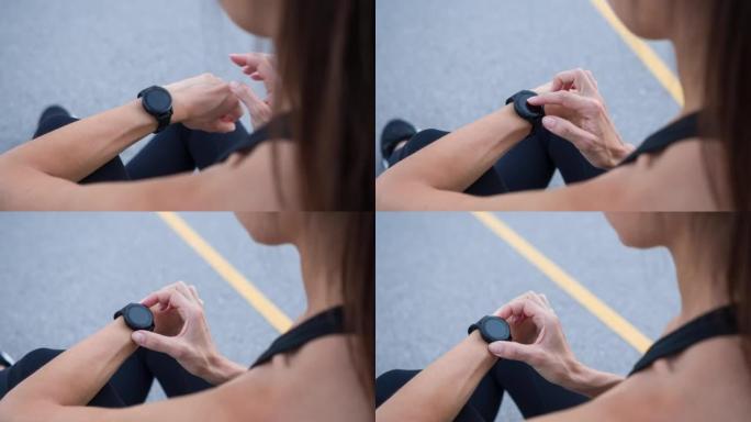 跑步后，女运动员在肩膀上查看她的智能手表的进度