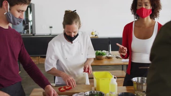 高加索女厨师教授戴口罩的多元化团体