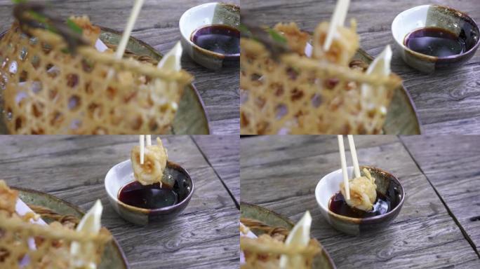 筷子拿起油炸鱿鱼油条，蘸酱。