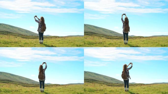 4k视频片段，一名妇女在远足时在山上拍照
