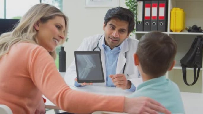 穿着白大褂的医生或全科医生会见母子预约看数字平板电脑的扫描-慢动作拍摄
