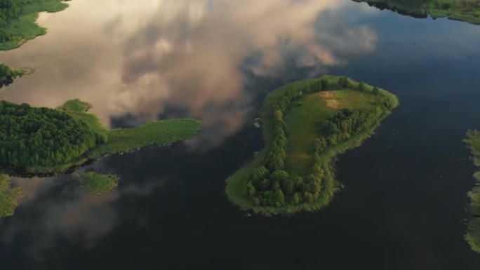 生态学概念。无人机在令人难以置信的静止湖上的小岛上方高高飞行，反射着白俄罗斯的云彩和天空。