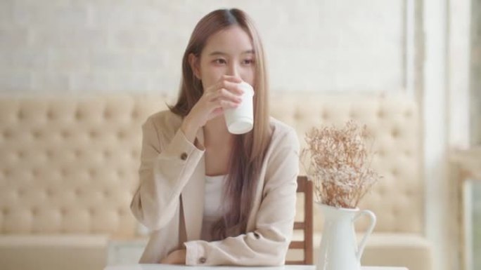 亚洲女性在时尚咖啡馆喝咖啡放松享受风味。