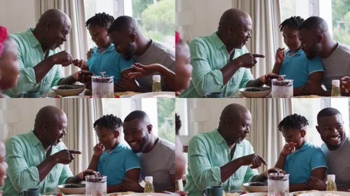 非裔美国人的祖父，父亲和儿子在家里一起使用智能手机时微笑着