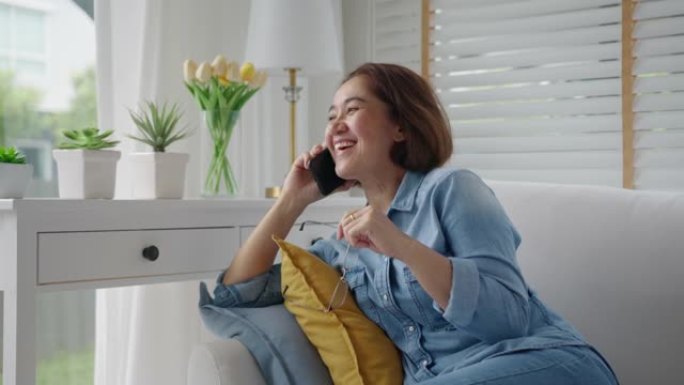 亚洲成熟的高级女人在家沙发上手机聊天快乐。
