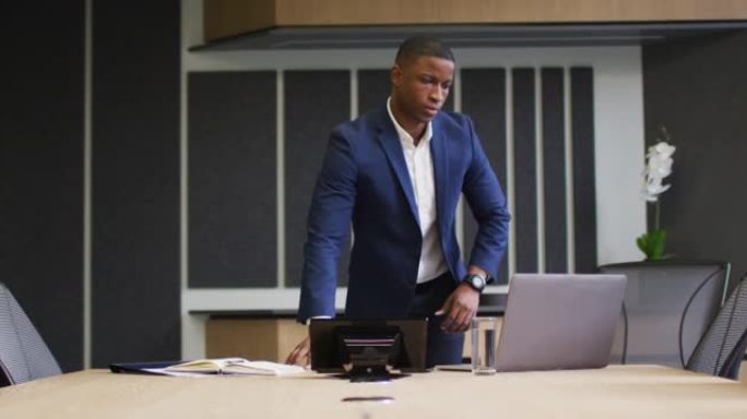 非裔美国商人在现代办公室的会议室中使用笔记本电脑
