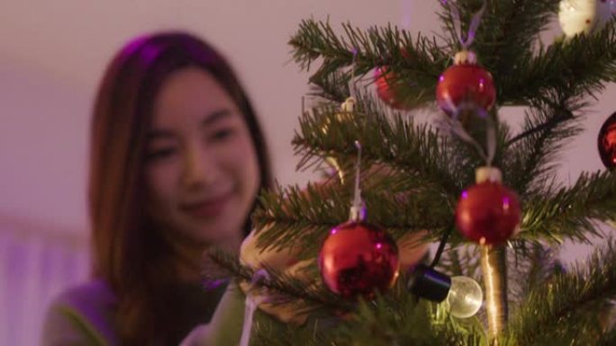 年轻女子装饰圣诞树。