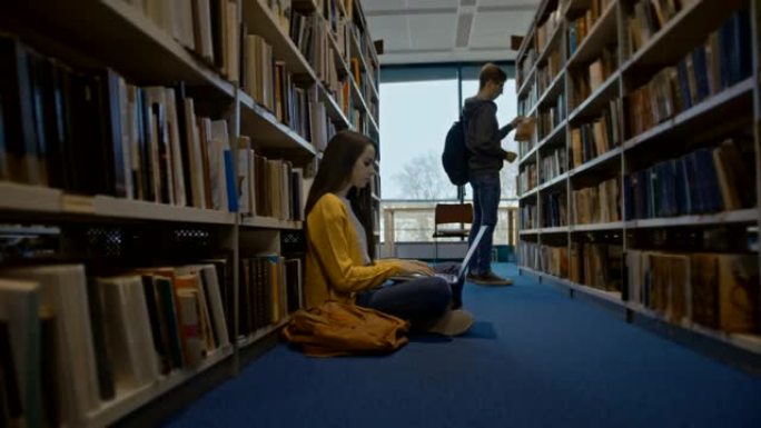 SLO MO女人使用笔记本电脑，而其他学生正在图书馆的书架上寻找书