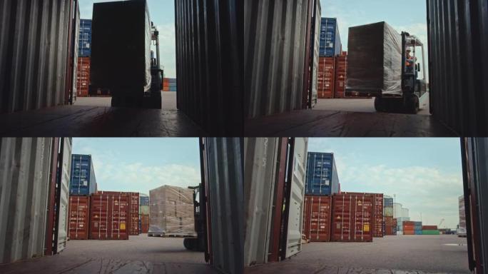 叉车司机在物流作业港口码头卸载带有完整托盘的货运集装箱，并带有纸板箱。从内部的摄像机视图显示了如何提