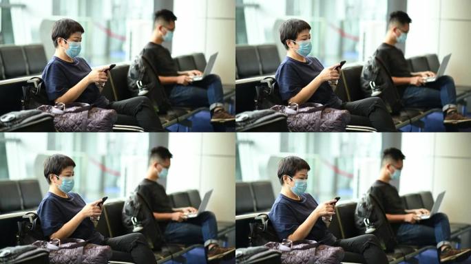 亚洲中国游客在机场用口罩观察社交距离
