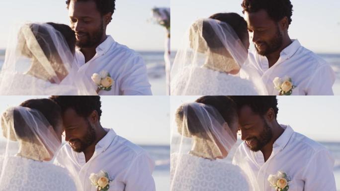 恋爱中的非裔美国夫妇结婚，在海滩上互相看着对方