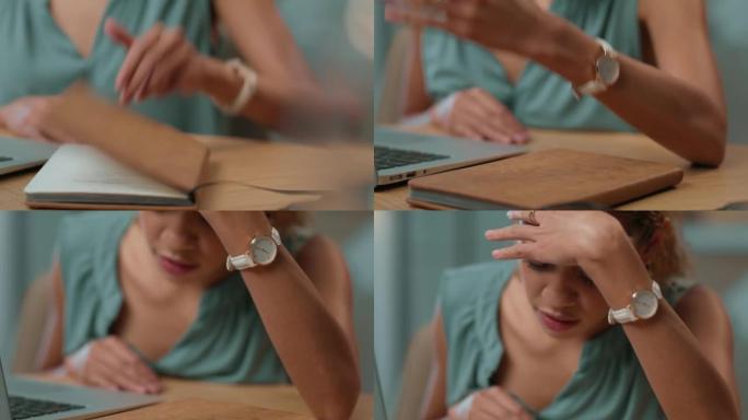 年轻的女商人在使用笔记本电脑并检查工作日记时，用拳头在桌子上敲打拳头。不快乐、沮丧的商业专业人士在工