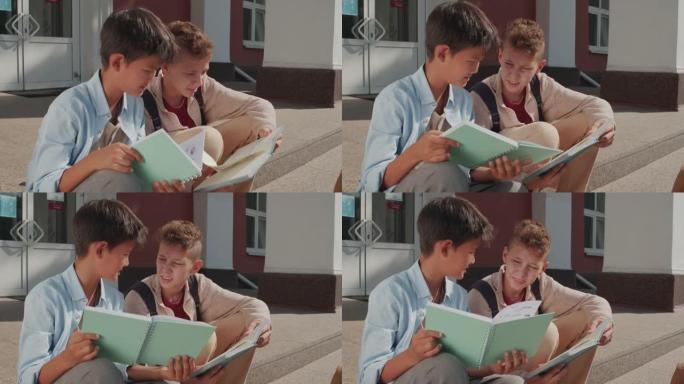 男孩在学校大楼的台阶上做作业