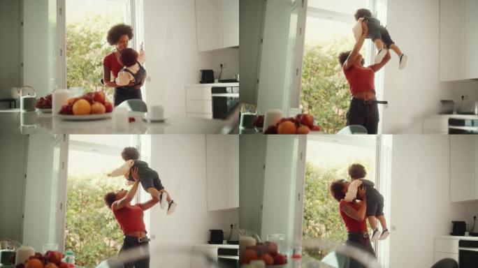 快乐的母亲抱着可爱的男婴，在现代家庭客厅玩耍，玩耍。非洲妇女举起并将蹒跚学步的孩子扔向空中。童年、新