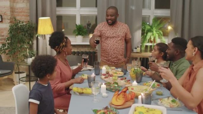 非洲男子在家庭晚餐时敬酒