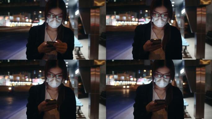 晚上使用智能手机戴口罩的女人