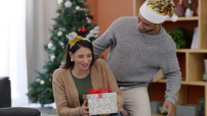一对年轻夫妇在家里休息室交换圣诞礼物的4k视频片段