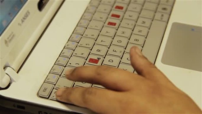 盲人或视障学校男孩的手学习使用带有突出按键的计算机来帮助视障人士。特写。