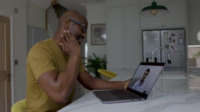 在家中的非裔美国成年男子在使用笔记本电脑进行远程医疗预约时向医生描述了自己的痛苦