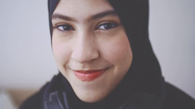 年轻的穆斯林妇女在头巾中的笑脸