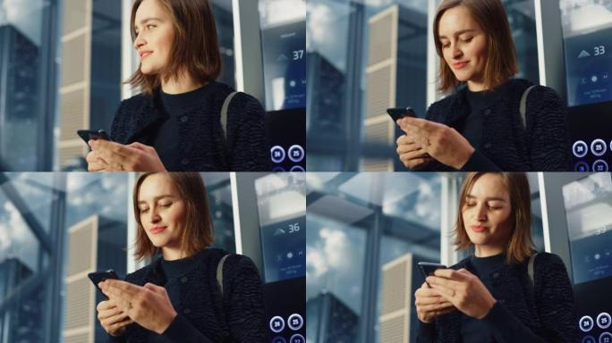 现代商务中心一名年轻的成年女性乘坐玻璃电梯到办公室的特写镜头。漂亮的经理使用智能手机编写消息，在电梯