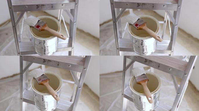 用油漆刷关闭梯子上的油漆罐