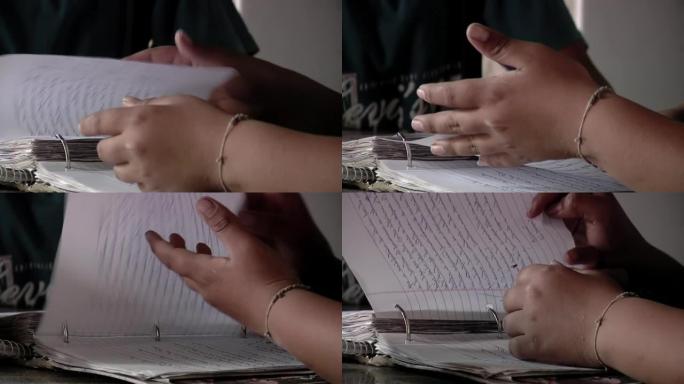 一名女中学生在课堂上在戒指活页夹上翻页的手。特写。