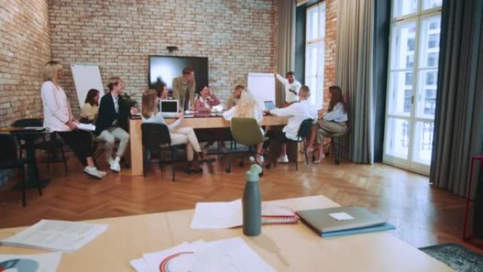 商务团队坐在现代办公桌会议上，从印度商务教练演讲研讨会上学习。