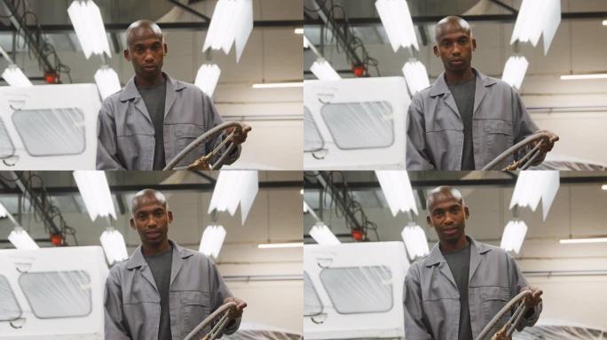 非裔美国男汽车修理工手持方向盘看镜头