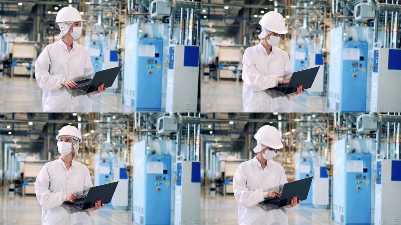 戴着口罩的工厂工程师正在将数据输入笔记本电脑