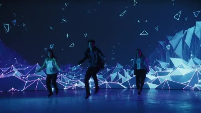 由三名专业舞者组成的多元化小组，在工作室环境中的虚拟制作期间，在带有VFX动画的大Led墙屏幕前表演