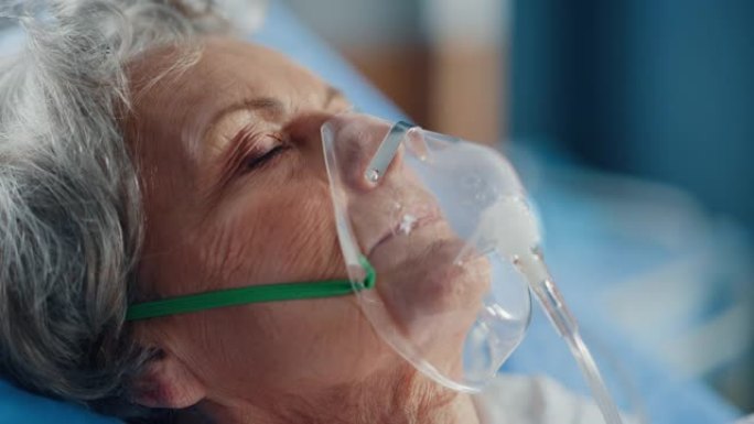 医院病房: 美丽的老年妇女戴着氧气面罩睡在床上，生病后完全康复。老太太梦想着自己的家人，朋友，幸福的
