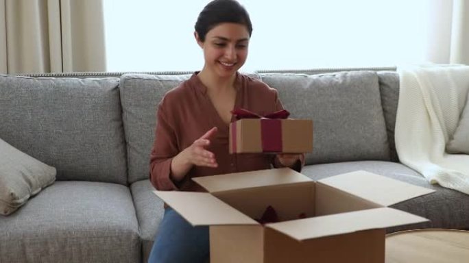快乐的印度女人打开带礼物的包装箱