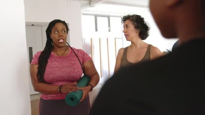 瑜伽课结束后，非洲妇女在健身房与一群人交谈