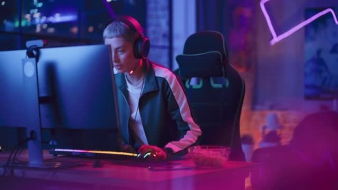 在家玩游戏: 女性玩家坐下来，戴上耳机在个人电脑上玩视频游戏。时尚的年轻女子在她的阁楼公寓享受在线锦