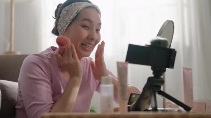 美丽的亚洲女人博主正在展示如何化妆和使用化妆品