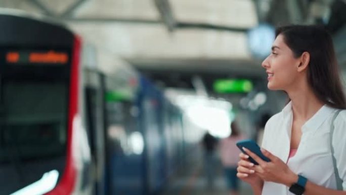 女人在地铁站通勤时使用电话并检查等待火车的时间