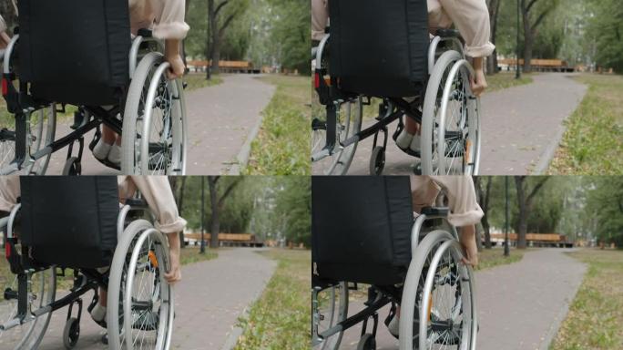 在公园户外骑轮椅的残疾妇女的特写慢动作
