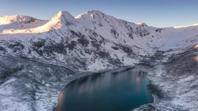 日出的光芒刚刚照亮了雪山，湖水仍静静地躺在雪山的怀抱中