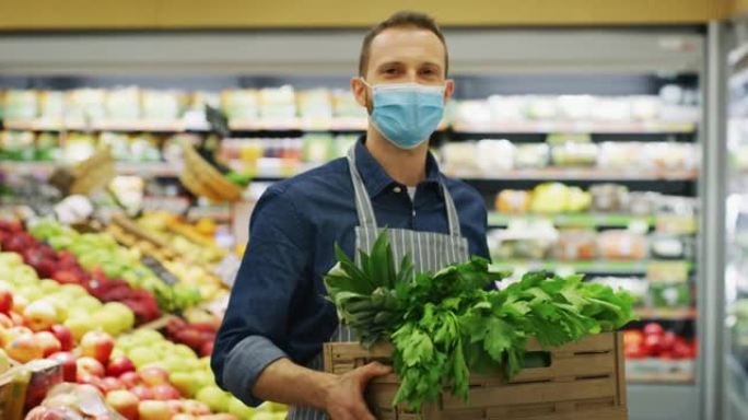 图为，在超市有机食品部工作的男职员戴着医用口罩，背着装着新鲜蔬菜的木箱，对着镜头满意地看着自己的工作