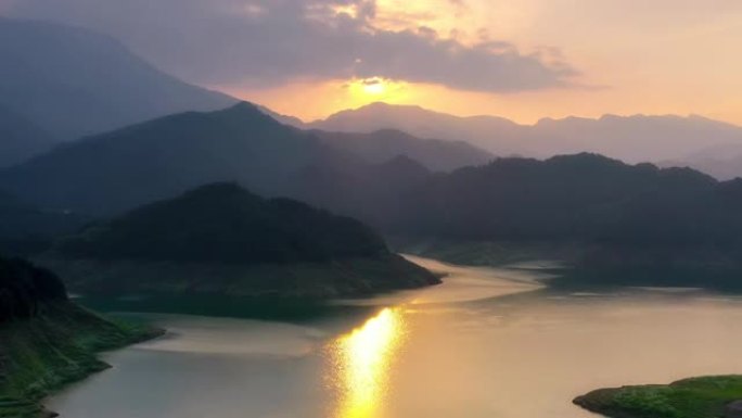 夕阳映照湖面，远处有山